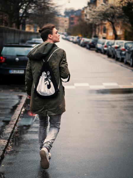Person Wearing Blue Jeans With Black and White Drawstring Bag