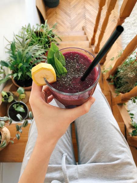 Person's Hand Holding Drinking Glass Filled With Smoothie