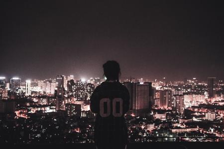 Photo of a Person Watching over City Lights during Night Time