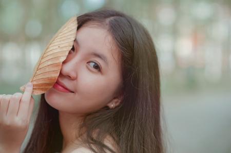 Photo of a Woman Holding a Dry Leaf