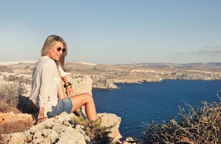 Photo of a Woman Sitting on the Cliff