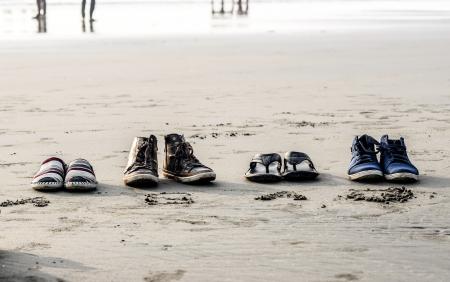 Photo of Assorted Pairs of Footwear on Sand