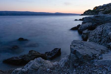 Photo of Calm Body of Water Beside Rock Formations