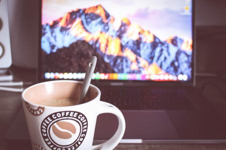 Photo of Cup of Coffee in Front of the Laptop