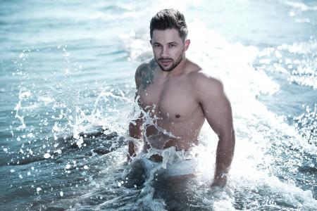 Photo of Man in Body of Water Wearing White Brief