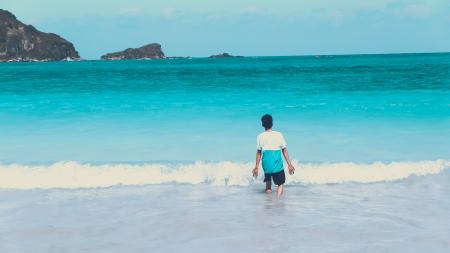 Photo of Man Walking by the Seashore