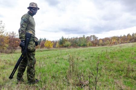 Photo of Man Wearing Green Combat Uniform Holding Rifle