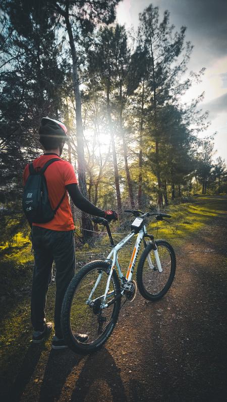 Photo of Man Wearing Red Shirt Holding White Mountain Bike