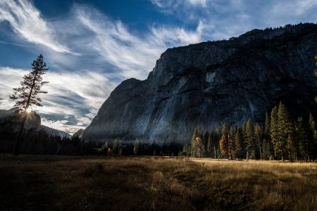 Photo of Mountain and Trees Under Cloudy Skies