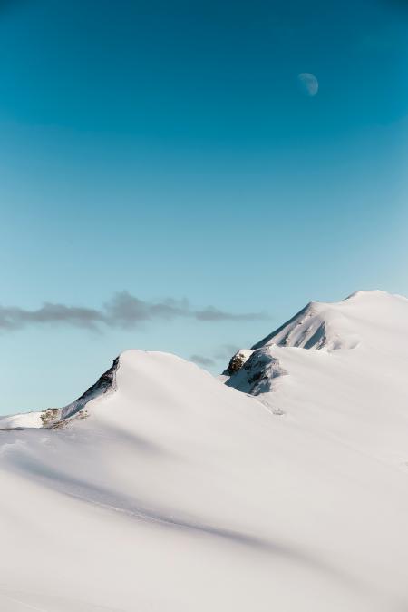 Photo of Mountain Range Covered With Snow Under Moon