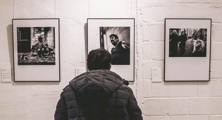 Photo of Person Standing in Front of Three Pictures