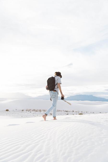 Photo of Person Walking Along Seashore