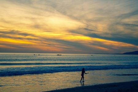 Photo of Person Walking on Beach Shore