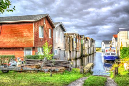 Photo of White and Blue Speedboat Beside Houses