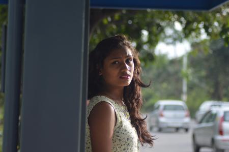 Photo of Woman in White Blouse Leaning on Gray Steel Shed