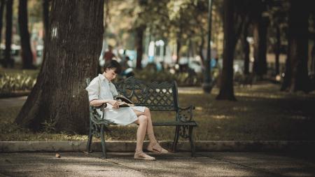 Photo of Woman Sitting in the Bench Near Tree
