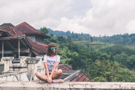 Photo of Woman Sitting on Concrete Balustrade