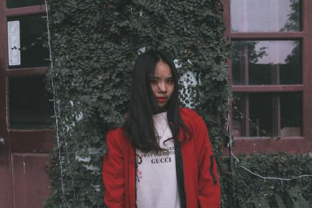 Photo of Woman Standing Near Window Wearing Red Jacket