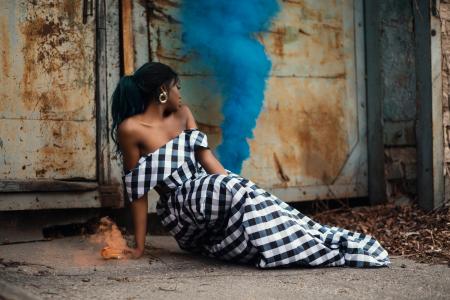 Photo of Woman Wearing White and Black Gingham Dress Sitting on the Floor