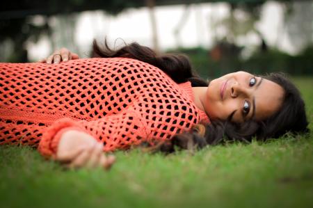 Photo Woman in Orange Long-sleeved Shirt Laying on Lawn