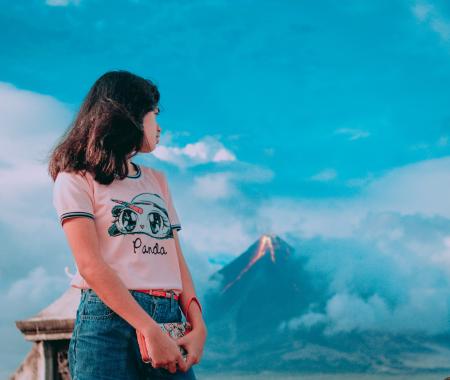 Photography of a Girl In Front of Erupting Volcano