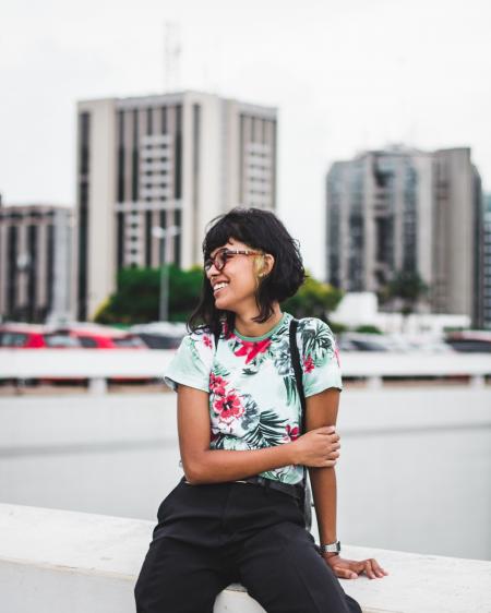 Photography of a Woman Sitting on a Ledge