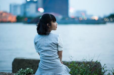 Photography of Woman Sitting Beside Body of Water