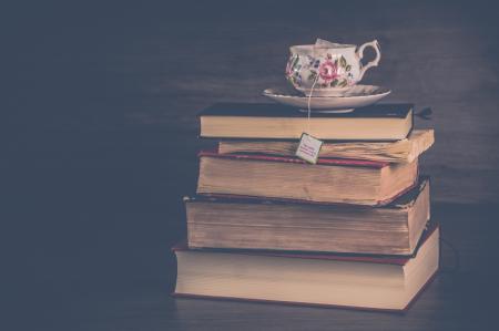 Pile of Hardbound Books With White and Pink Floral Ceramic Teacup and Saucer