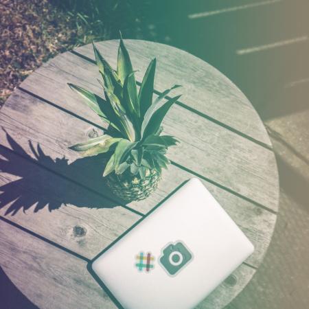 Pineapple Fruit Near White Laptop Computer on Brown Wooden Table