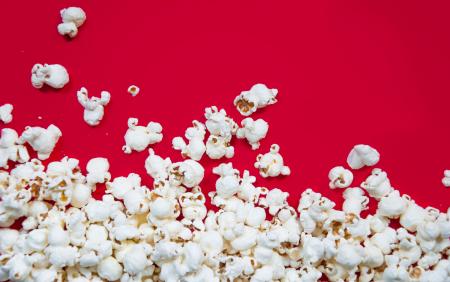 Popcorn spilled on red background