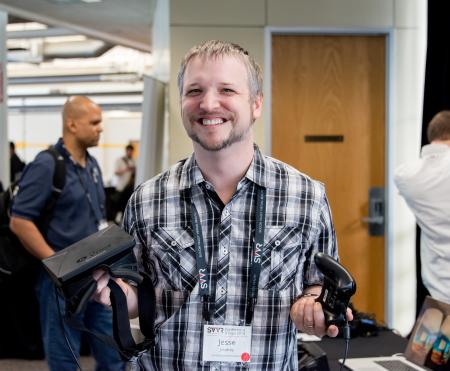 Posed portrait of Jesse Joudrey (Jespionage) at SVVR holding Oculus Rift DK1 and controller