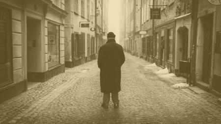 Rear View of a Man Walking on Cobblestone