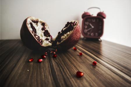 Red and White Round Fruit on Brown Wooden Table With Red Alarm Clock