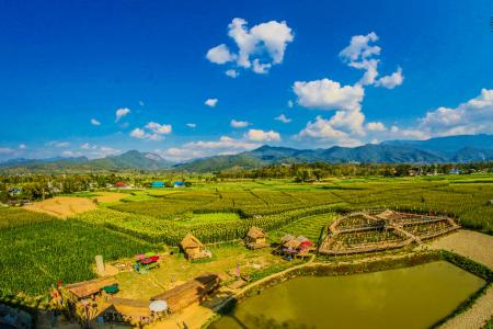 Rice Field With Mountain and Houses during Cloudy Day