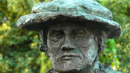 Rock Statue of Man Beside Green Leaves