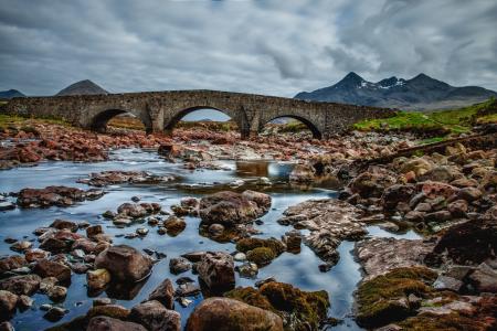 Rocky Body of Water With View of Concrete Bridge at Daytime