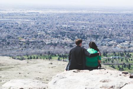 Romantic couple hugging sitting on a rock