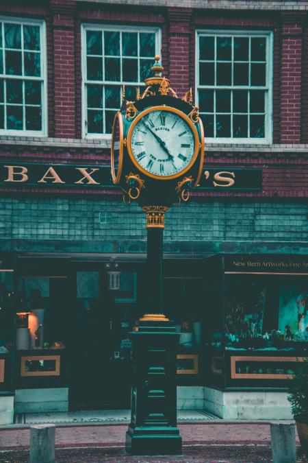 Round Yellow and Black Analog Pedestal Clock Displaying 4:58