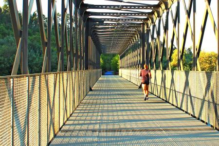 Runner crossing a metal bridge