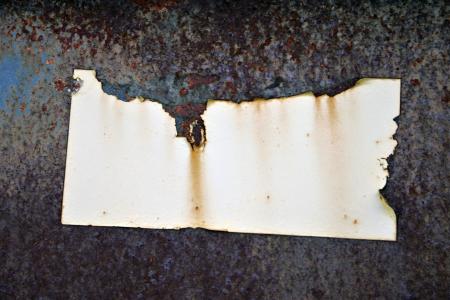 Rusted metal plate with sticker