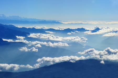 Scenic View of Clouds over Mountains Against Blue Sky