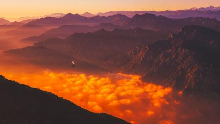 Scenic View of Mountains Against Dramatic Sky at Sunset