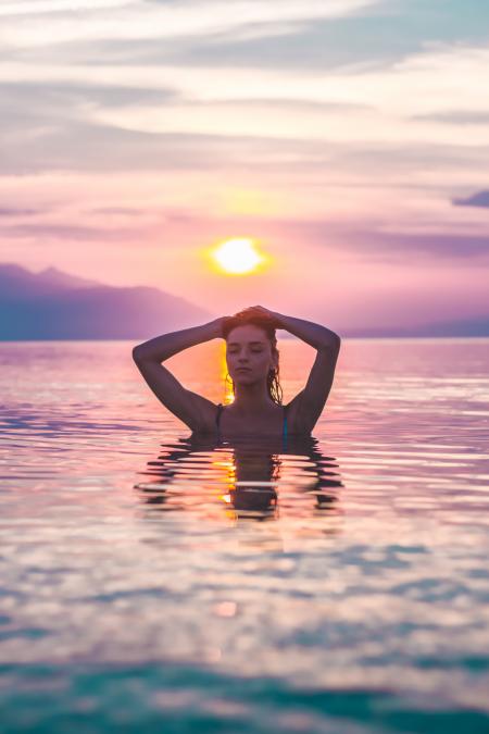 Selective Focus Photo of a Woman Bathing in Body of Water during Golden Hour