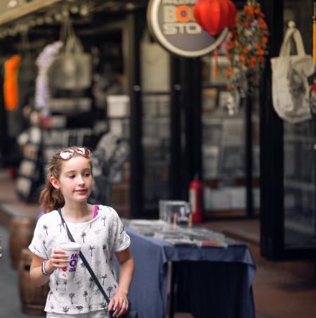 Selective Focus Photo of Girl Wearing Gray and Black Tree Print Holding Mcdonald Plastic Cup