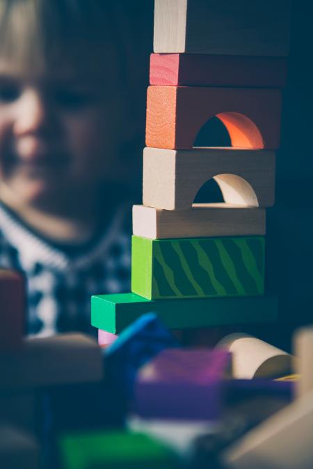 Selective Focus Photography of Beige Orange Red and Green Blocks Piled Vertically