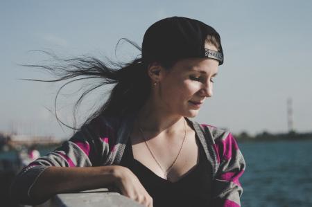 Selective Focus Photography of Female Wearing Black Snapback Near Ocean