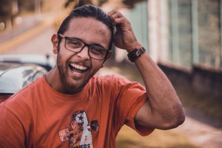 Selective Focus Photography of Man Smiling Putting Hands on Head