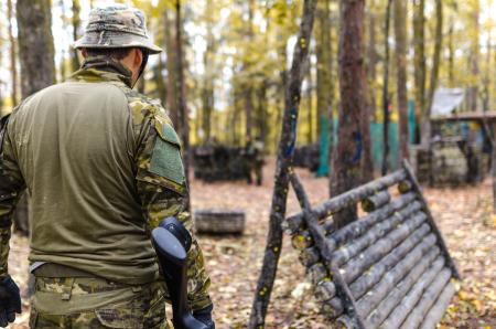 Selective Focus Photography of Man Wearing Camoflouge Suit While Holding a Gun