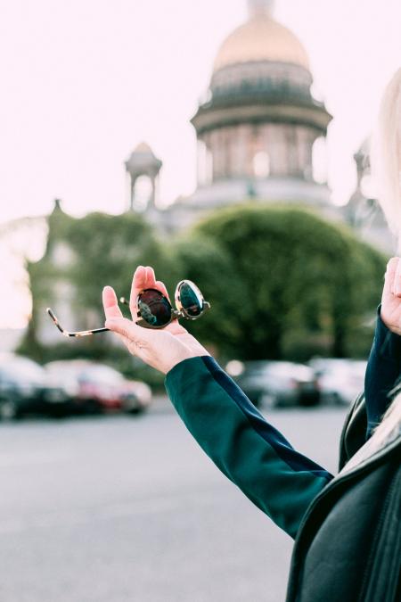 Selective Focus Photography of Person Holding Black Round Sunglasses