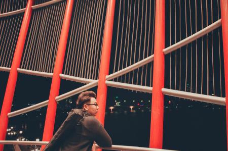 Selective Photography of Man Leaning on White Metal Railings